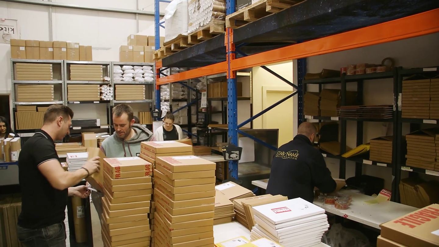 The Cufilo team packing personalised orders between warehouse racking